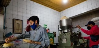 Mexicans working hard in a tortilla shop