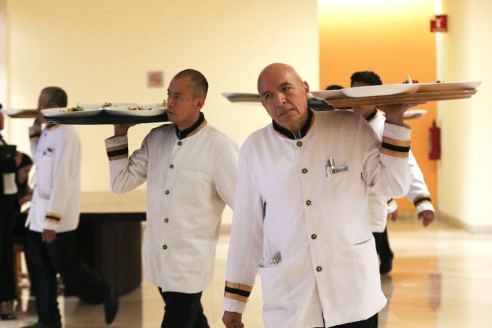 Waiters carrying trays in a hotel