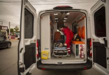 An EMT loads a person on a stretcher into an ambulance.
