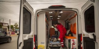 An EMT loads a person on a stretcher into an ambulance.
