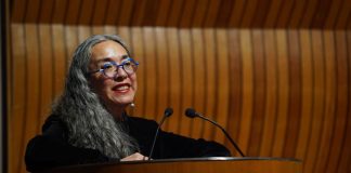 Author Cristina Rivera Garza at a podium with microphones