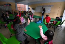 Children raise their hands in a Mexican classroom