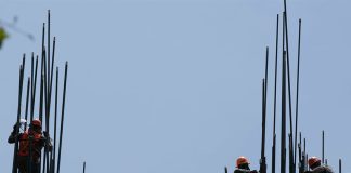 Construction workers setting up the metal support rods to a building, an image to illustrate foreign investment in Mexico