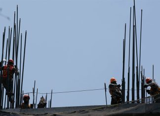 Construction workers setting up the metal support rods to a building, an image to illustrate foreign investment in Mexico