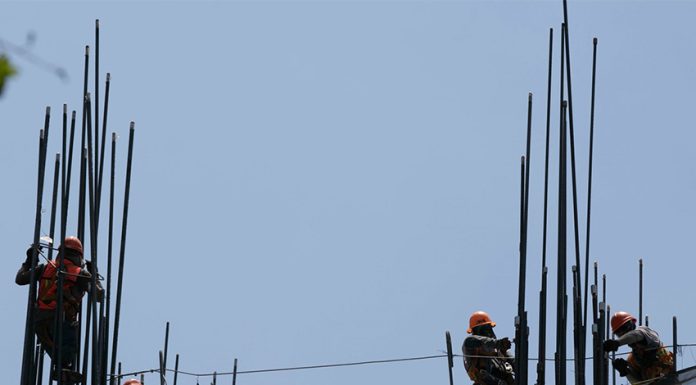 Construction workers setting up the metal support rods to a building, an image to illustrate foreign investment in Mexico