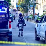 A National Guard agent stands between two police vehicles on a cordoned-off street outside of El Pueblito market in Acapulco, Guerrero,.