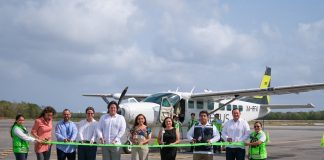 Quintana Roo governor Mara Lezama and state officials cut green tape in front of an Aerus plane.