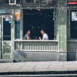 Two men having a conversation at a bar