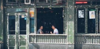 Two men having a conversation at a bar