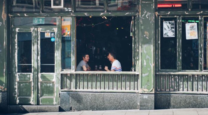 Two men having a conversation at a bar