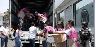 INE workers in Puebla unload ballot boxes for the Mexican elections, while soldiers and official observers watch.