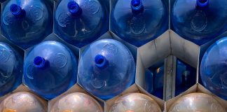 Empty 20-gallon plastic jugs of water arranged in a pile, pyramid style