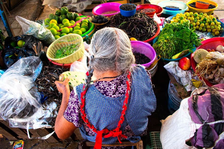 A woman sells vegetables at a market