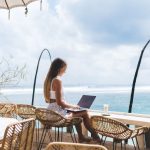girl working from the beach as a digital nomad