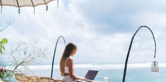 girl working from the beach as a digital nomad
