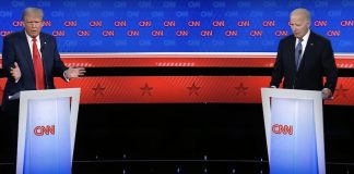 U.S. President Biden and Trump debate issues like immigration, border security and more from behind podiums on a stage.