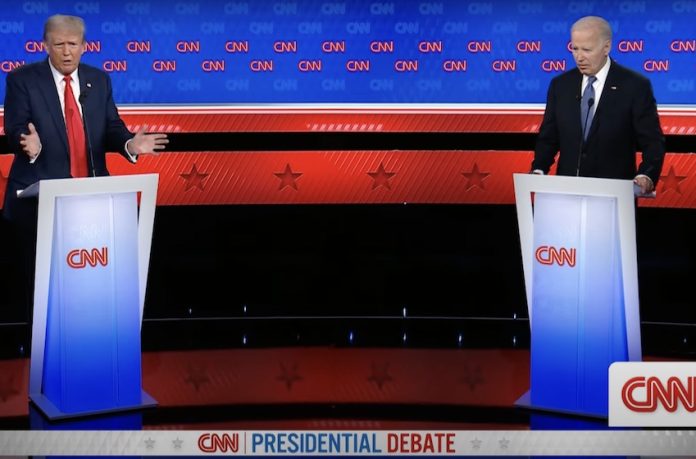 U.S. President Biden and Trump debate issues like immigration, border security and more from behind podiums on a stage.