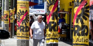 A man walks by PRD campaign posters on posts in Mexico City