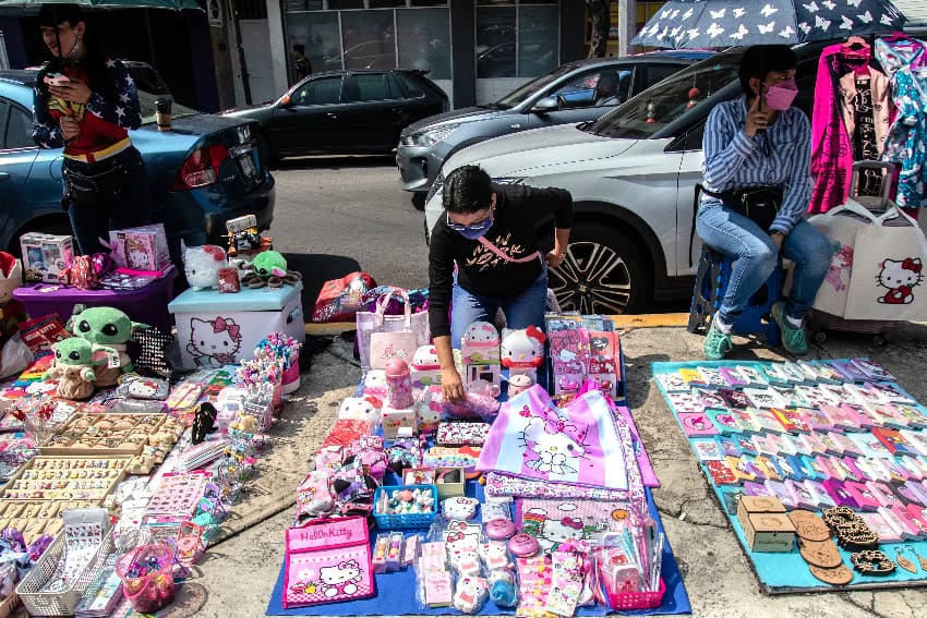 A street vendor sells Hello Kitty merchandise on the sidewalk