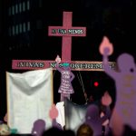 Protesters against violence against women hold a cross