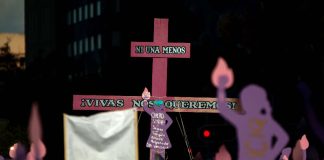 Protesters against violence against women hold a cross