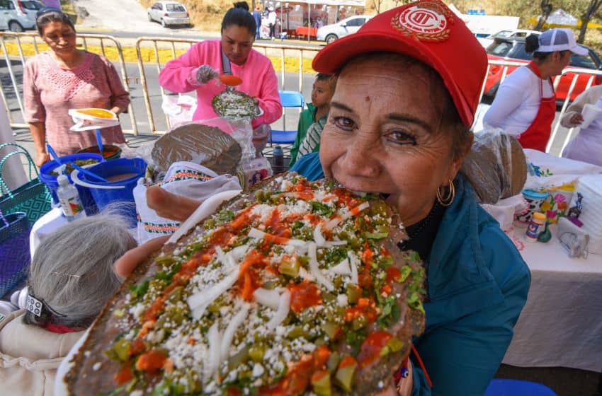Woman eating a big huarache in Toluca, Mexico