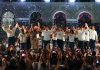 Morena gubernatorial candidate Javier May holds hands on stage with his campaign team, as confetti rains down.