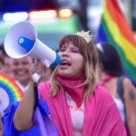 A girl holds a speaker during a pride event in Acapulco, Mexico