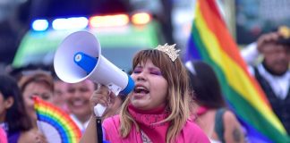 A girl holds a speaker during a pride event in Acapulco, Mexico