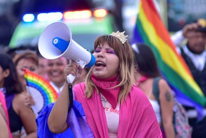A girl holds a speaker during a pride event in Acapulco, Mexico