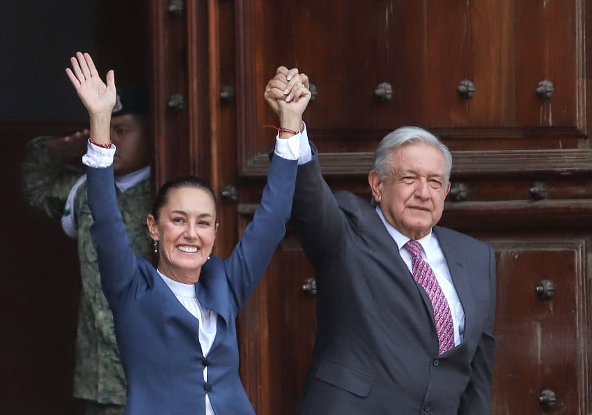 Claudia Sheinbaum and Andrés Manuel López Obrador hold hands in the air
