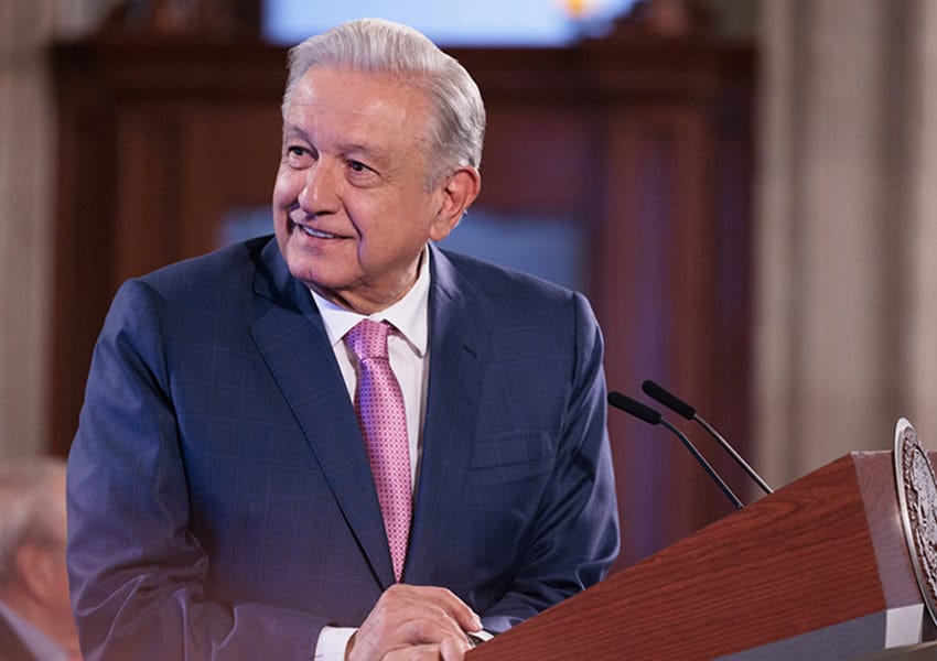 Mexico's President Lopez Obrador in a suit standing at a podium at a press conference in the national palace discussing Mexico-U.S. international bridge projects that were approved Tuesday.