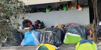The remains of a tent encampment, much of it bundled in trash bags.