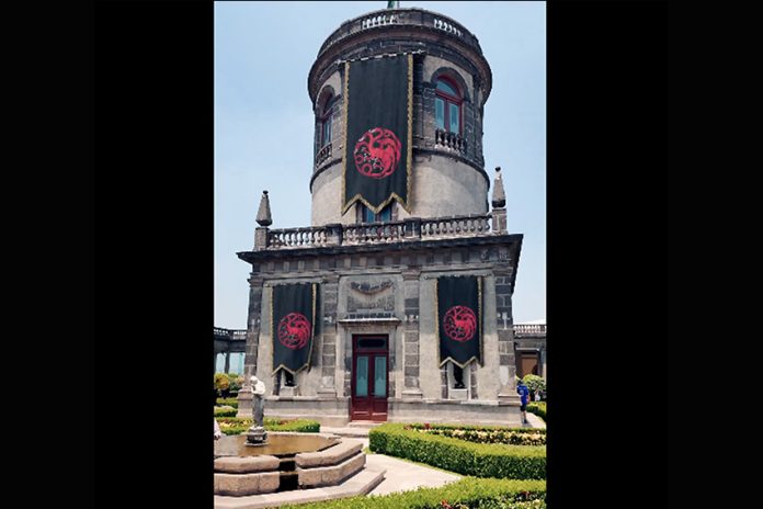 Part of Chapultepec Castle with what looks like three black and red banners hanging from it