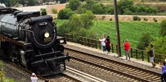 Bystanders gather to watch the passage of the Empress, a black steam locomotive, through Tula de Allende, Hidalgo, on its way to Mexico City.