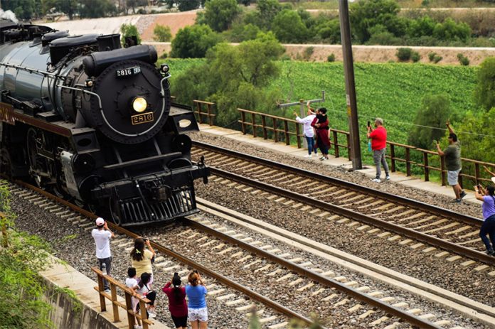Bystanders gather to watch the passage of the Empress, a black steam locomotive, through Tula de Allende, Hidalgo, on its way to Mexico City.