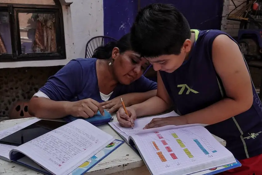 A Mexican mother helps her son with his school work