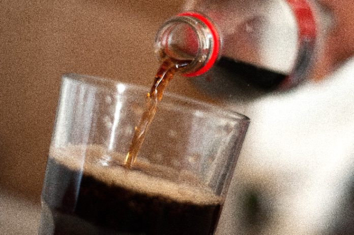 A glass with Coca Cola poured into it