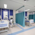 IMSS hospital ward in Juchitan, Oaxaca, with three empty stalls with hospital beds and medical equipment.