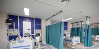 IMSS hospital ward in Juchitan, Oaxaca, with three empty stalls with hospital beds and medical equipment.