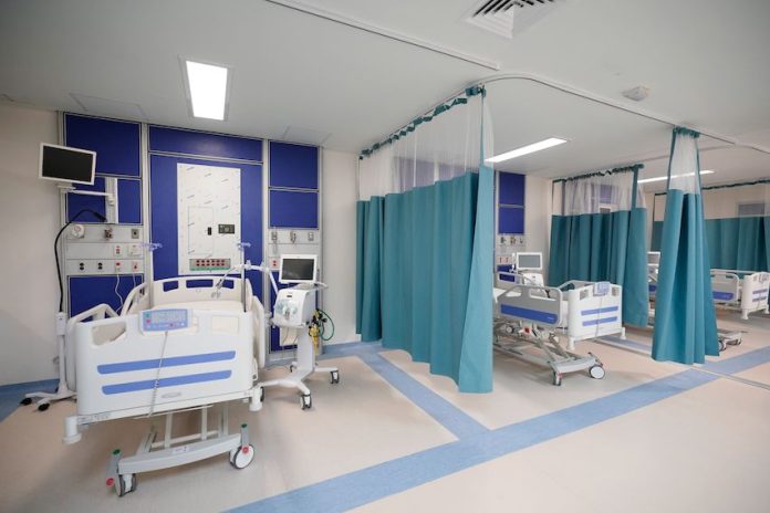 IMSS hospital ward in Juchitan, Oaxaca, with three empty stalls with hospital beds and medical equipment.