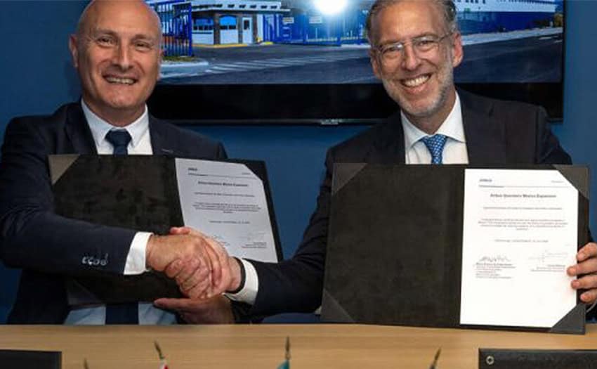 Airbus Helicopters Executive Vice President of Operations Laurent Mazoue and Queretaro Minister of Sustainable Development Marco Antonio del Prete shake hands while posing for a photo and holding up an agreement between Airbus and the Queretaro government