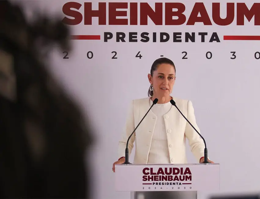 President-elect Claudia Sheinbaum standing at a podium talking to reporters about the arrest of Joaquin Guzman Lopez and Ismael "El Mayo" Zambada.