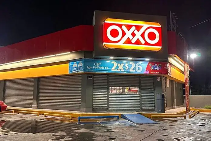 A closed Oxxo store at night with corrugated metal garage style doors covering all doors and windows to the store.