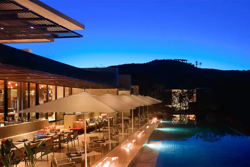 A luxury outdoor dining area overlooking a pool in the Montage, a luxury site in Los Cabos.