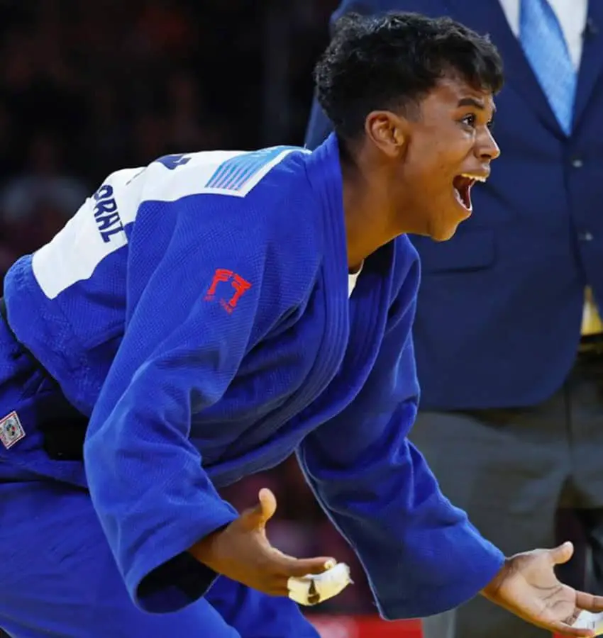 Prisca Awiti in the Paris 2024 Olympic semifinals, where she won the silver medal, hunched in sparring position with her palms out and her mouth wide open.