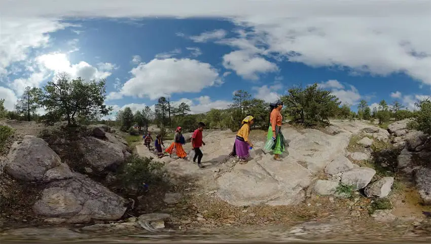 A group of colorfully dressed people walk through a rocky landscape, in a shot from "GAWI," a VR film that will be shown at the Guanajuato International Film Festival.