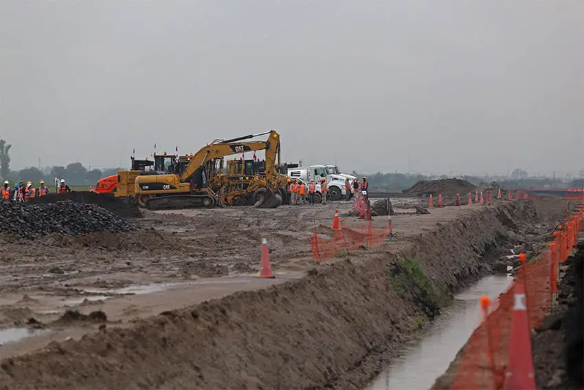 Construction equipment works in a barren field to build a runway for Guadalajara airport.