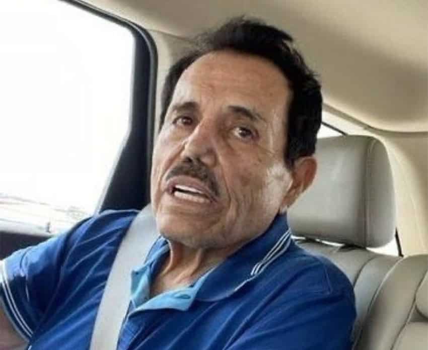 El Mayo Zambada, older and thinner than in other photos, in a car wearing a blue shirt.