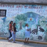Residents of the Nahua town Cuentepec in Morelos walk by a multi-lingual mural.